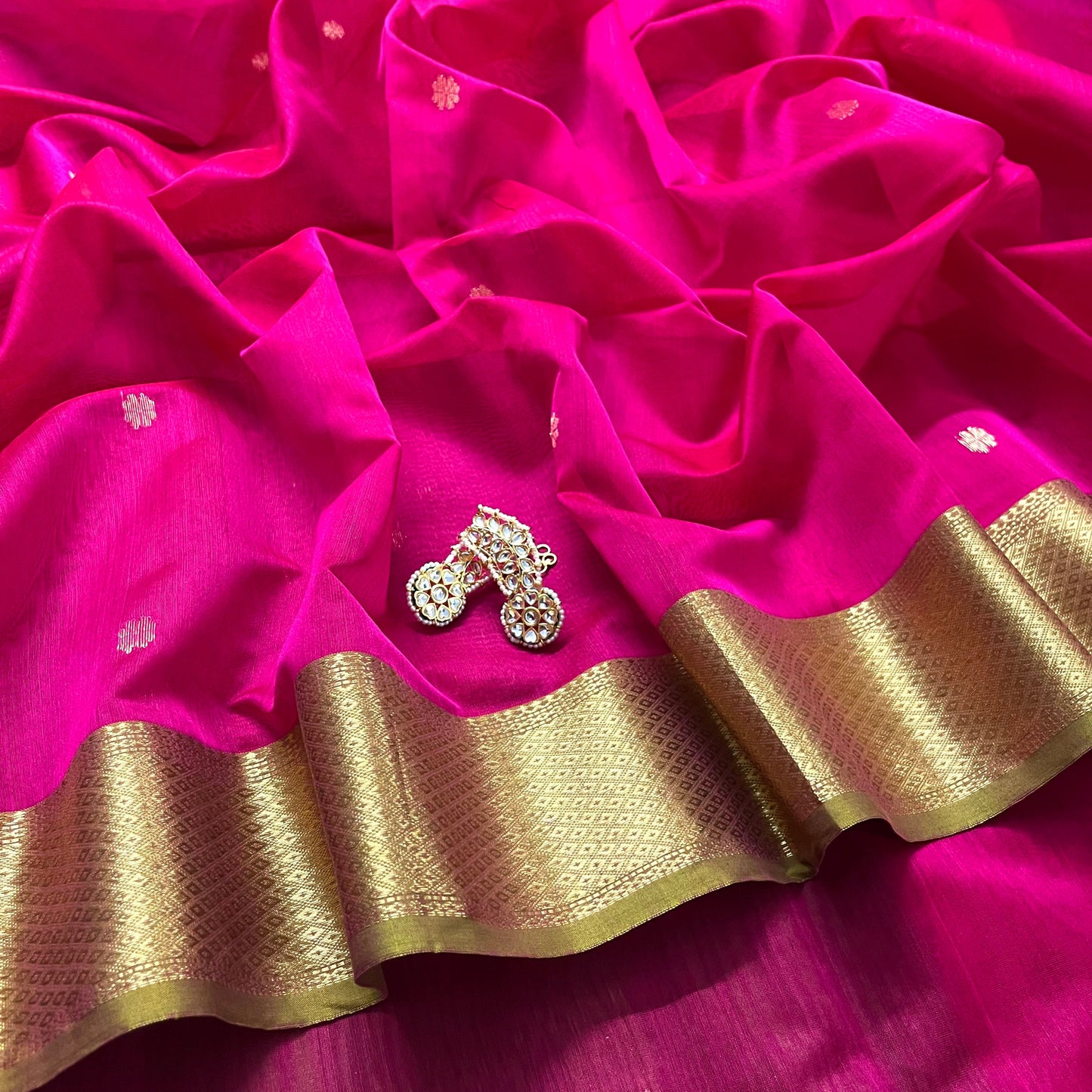 Pink and olive green Maheshwari saree with flower motifs on pallu